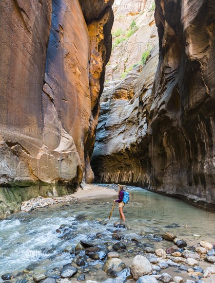 Hiker walking through river