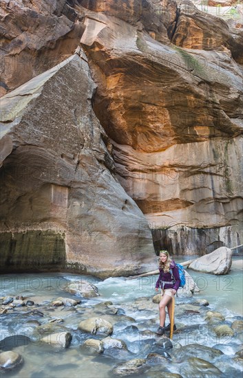 Hiker walking through river