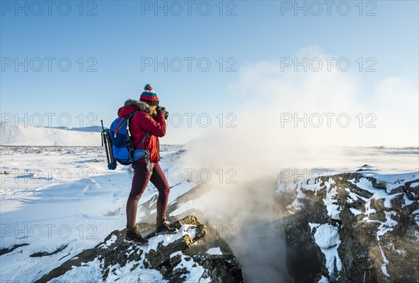 Woman standing at divergent tectonic boundary between North American and Eurasian plates