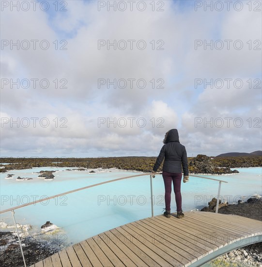 Tourist on a wooden bridge at the Blue Lagoon near Gratdavik