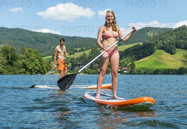 Young man and woman on paddle boards