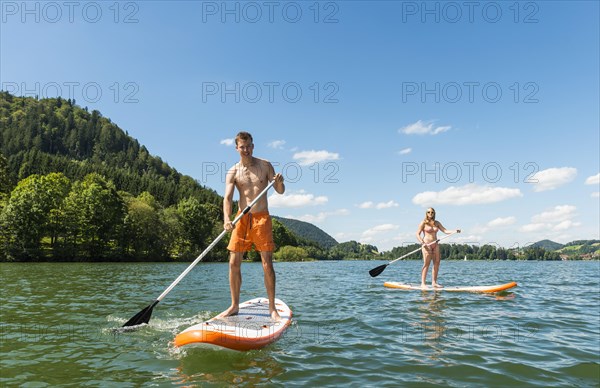 Young man and woman on paddle boards