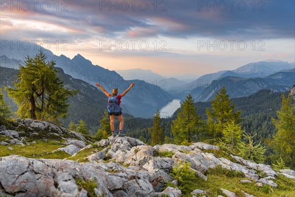 Hiker stretches arms into the air