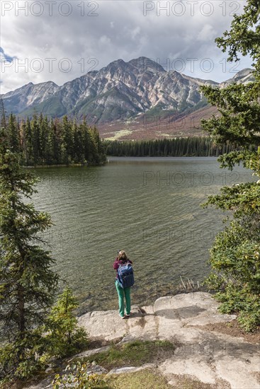 Female hiker stands on the lakeshore