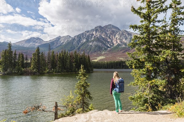 Female hiker stands on the lakeshore