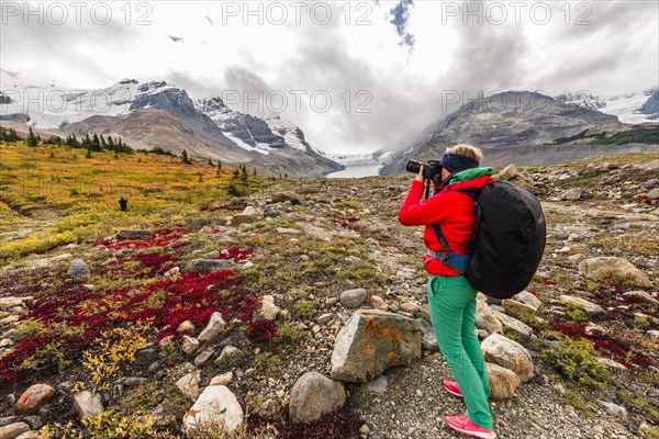 Young woman photographs barren landscape