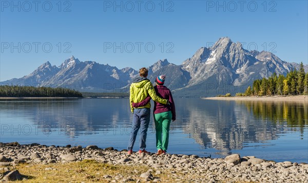 Young woman and young man standing side by side on the shore