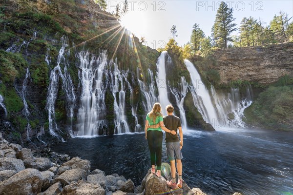 Young couple standing at a waterfall