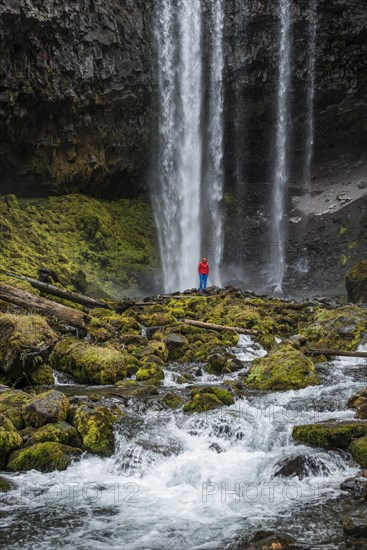 Hiker in front of a high waterfall