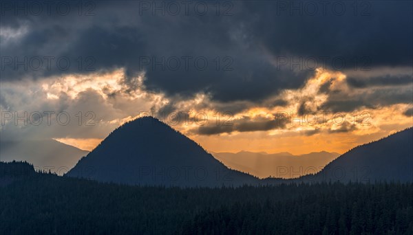 Hilly wooded mountain landscape at sunset with dramatic clouds