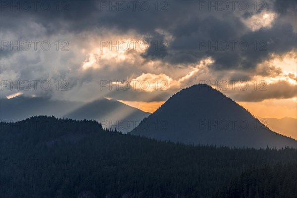 Hilly wooded mountain landscape at sunset with dramatic clouds