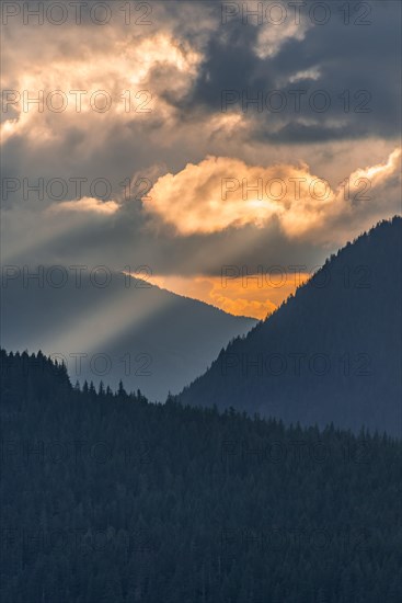 Hilly wooded mountain landscape at sunset with dramatic clouds