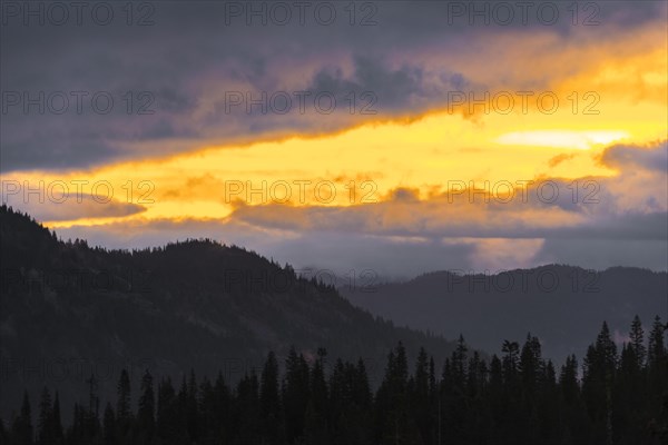 Hilly wooded mountain landscape at sunset with dramatic clouds