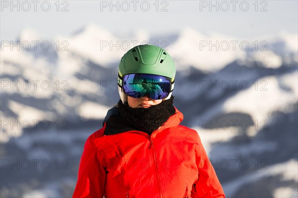 Female skier with ski helmet and ski goggles looks into the camera