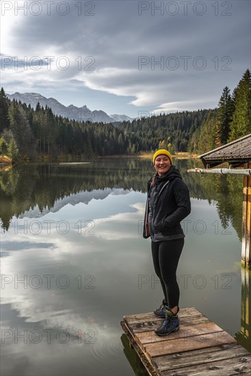 Young female hiker standing on a footbridge at Grubsee