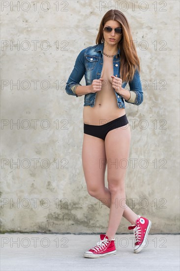 Young woman posing with jeans jacket