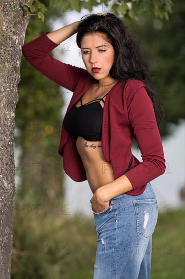 Portrait of a young woman with a wine red jacket and blue jeans