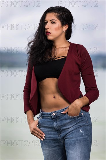 Portrait of a young woman with a wine red jacket and blue jeans