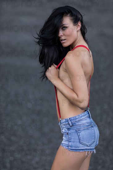 Woman with jeans hotpants and red suspenders