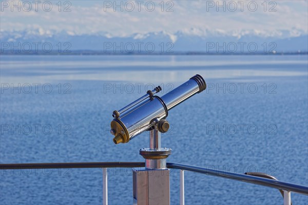 Binoculars with view to the snow-covered alpine peaks