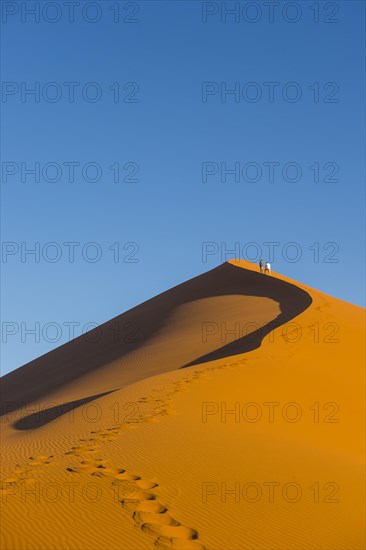 Woman walking up the giant sanddune Dune 45