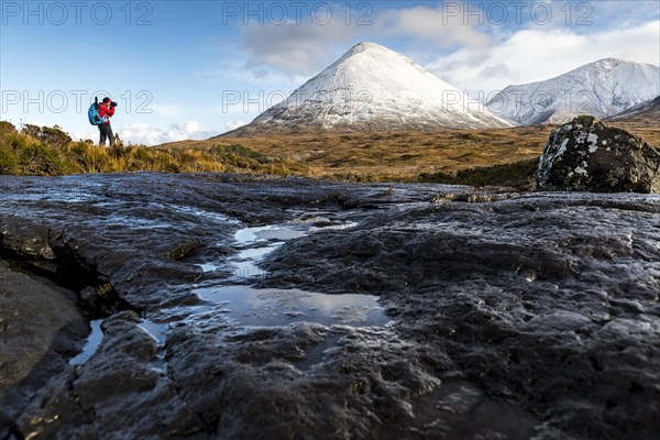 Photographer with snow-covered peaks of the Cullins Mountains