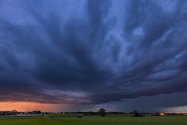 Thunderstorm sky with small village and meadows landscape