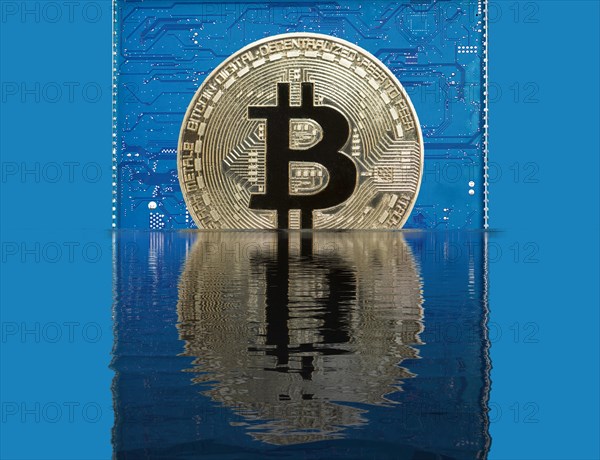 Bitcoin on a blue circuit board sinks into water