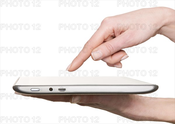 Finger pointing at a tablet computer screen