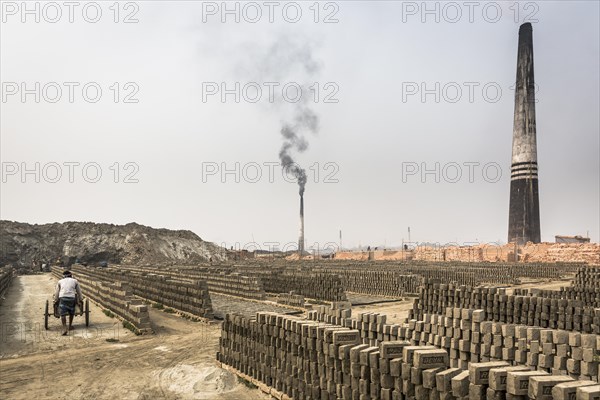 Stack of bricks with burning towers in a brickyard