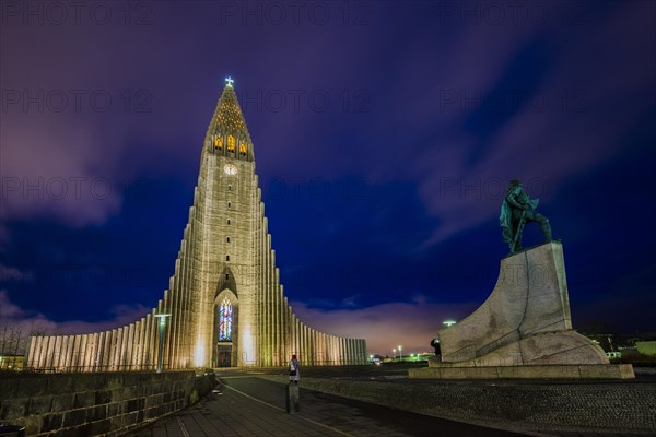 Illuminated church Hallgrimskirkja with monument of Leif Eriksson