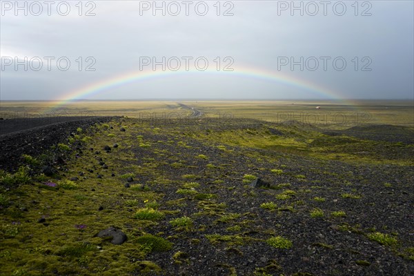 Rainbow over flat volcanic landscape near Braidarmerkursandur