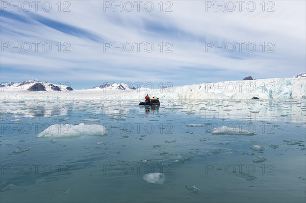 Zodiac boat with tourists navigating in front of Lilliehook glacier