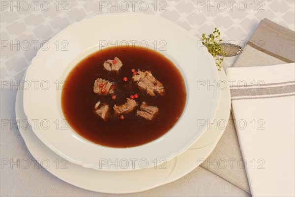 Oxtail soup with red pepper in soup plate