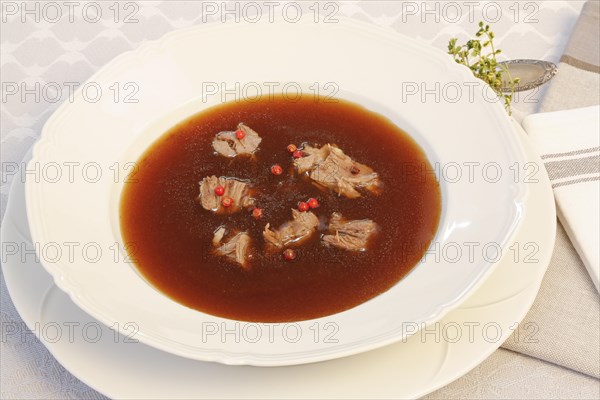 Oxtail soup with red pepper in soup plate