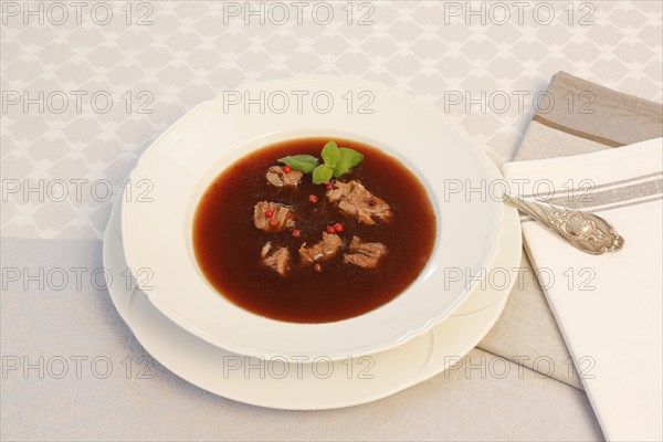 Oxtail soup with red pepper in soup plate