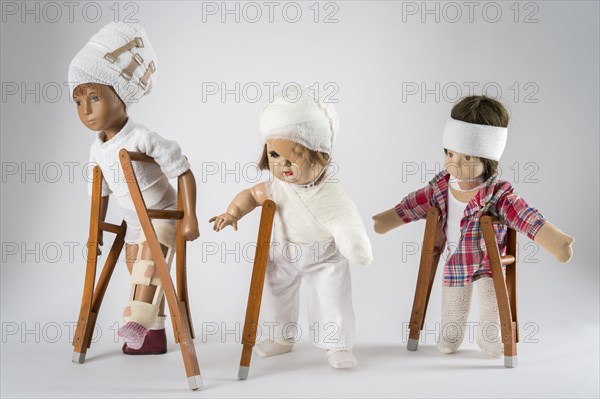 Three dolls walking with crutches