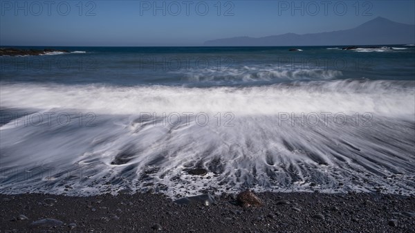 Black pebble beach with wave hem
