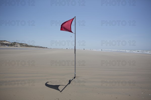Red flag on the beach warn against dangerous drifts