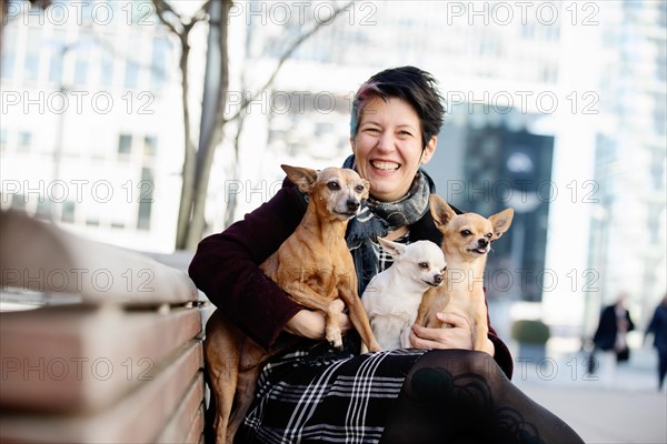 Laughing woman with three dogs on her lap