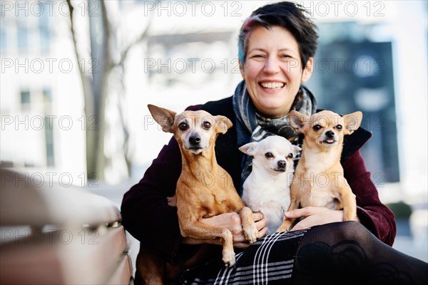 Laughing woman with three dogs on her lap