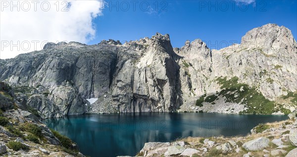 Mountain lake Lac de Capitello surrounded by steep faces