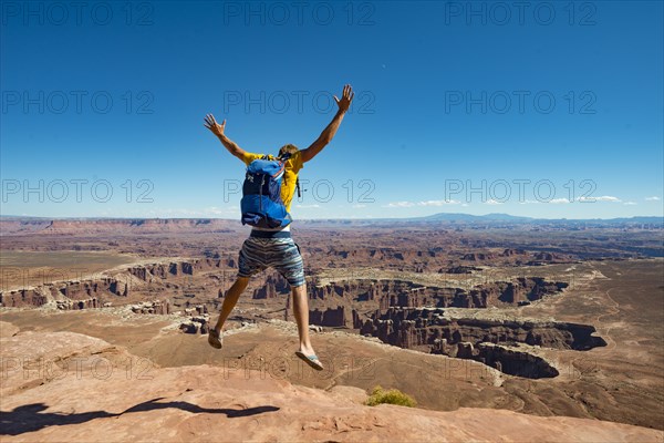 Young man jumping with outstretched arms