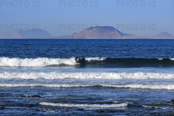 Wave surfers on waves at Caleta de Famara
