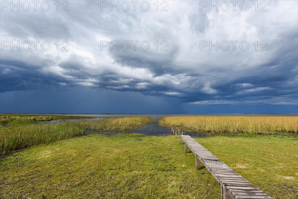 Footbridge at the lakeside with dramatic sky