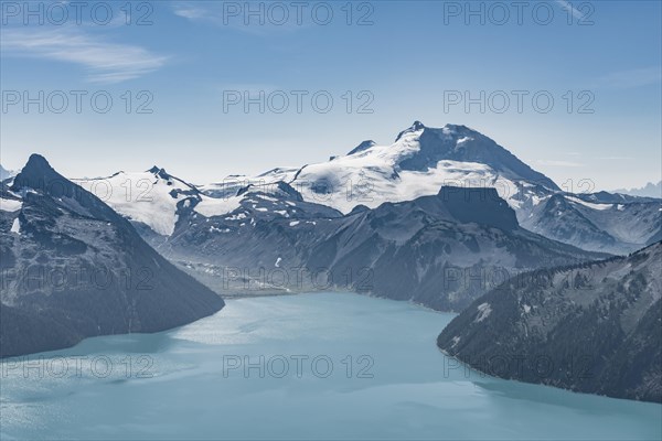 Turquoise Glacial Lake Garibaldi Lake in front of mountain range with snow and glacier