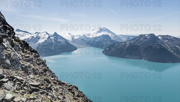 Turquoise Glacial Lake Garibaldi Lake in front of mountain range with snow and glacier