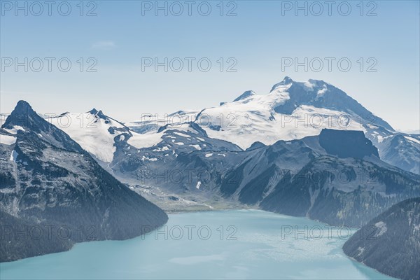 Turquoise Glacial Lake Garibaldi Lake in front of mountain range with snow and glacier
