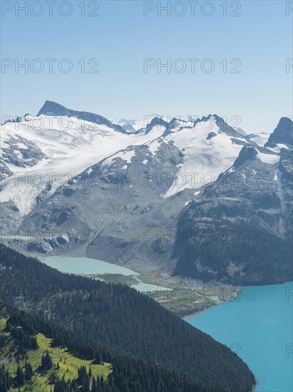 Turquoise Glacial Lake Garibaldi Lake in front of mountain range with snow and glacier