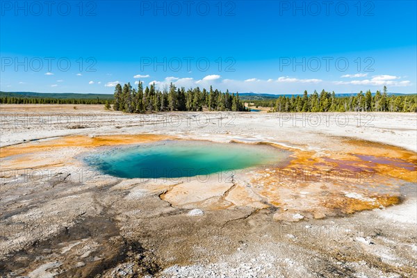 Steaming hot spring with colored mineral deposits